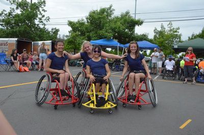 Four players in navy shirts pose on the court in front of blue canopy tents