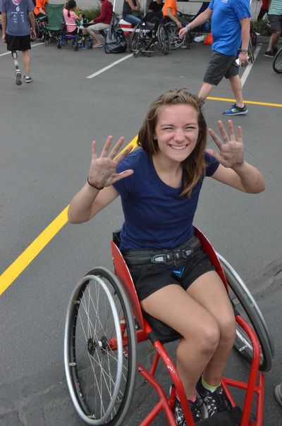 Player in a navy shirt grins and shows both palms from a red wheelchair