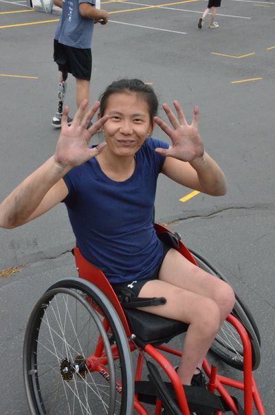 Player in navy holds up both palms, darkened from pushing the wheels