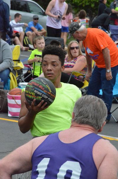 Player in neon yellow looks to pass as a defender in purple 10 guards him