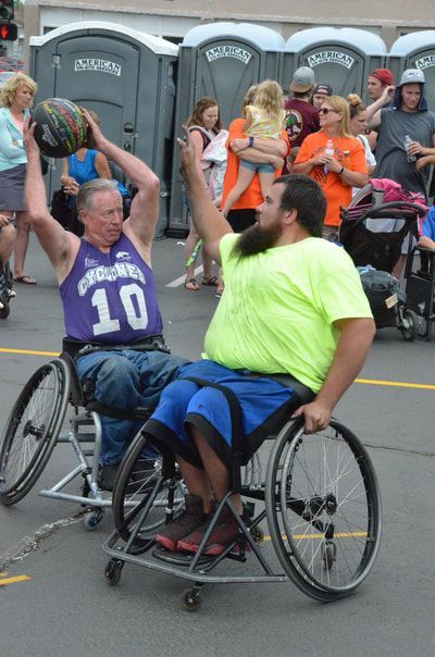 Player in purple 10 holds the ball overhead as a player in yellow defends
