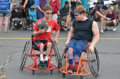 Da Burds player in red carries the ball beside a defender in a black tank