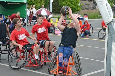 Player in a black tank top shoots over two Da Burds players in red