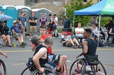 Da Burds player holds the ball between two defenders in black tank tops