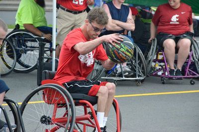 Da Burds player in glasses dribbles the ball low beside his red wheelchair