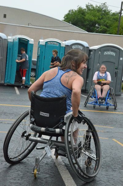 Player in a blue tank looks back over her shoulder and smiles mid-game