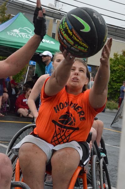Player in an orange shirt and an opponent both reach up for a rebound