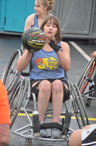 Player in a blue tank holds the ball at her chest, ready to pass