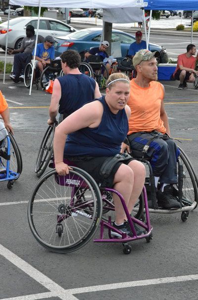 Player in a navy tank pushes up the court beside a player in an orange tank