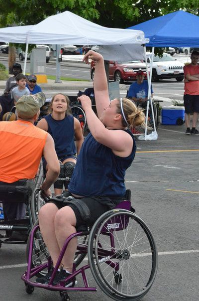 Player in a navy tank shoots one-handed as a defender in orange looks on