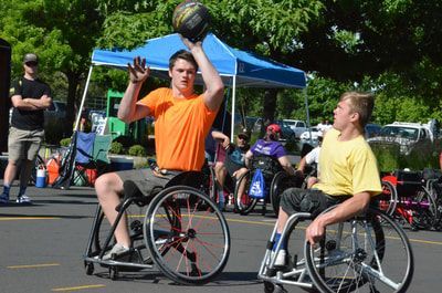 Player in an orange shirt shoots over a defender in a yellow shirt