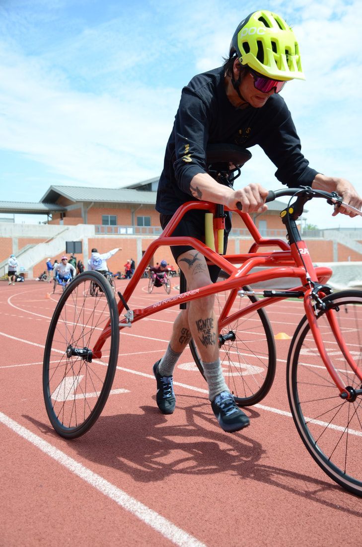 Athlete in a yellow helmet strides forward on a red RaceRunner frame