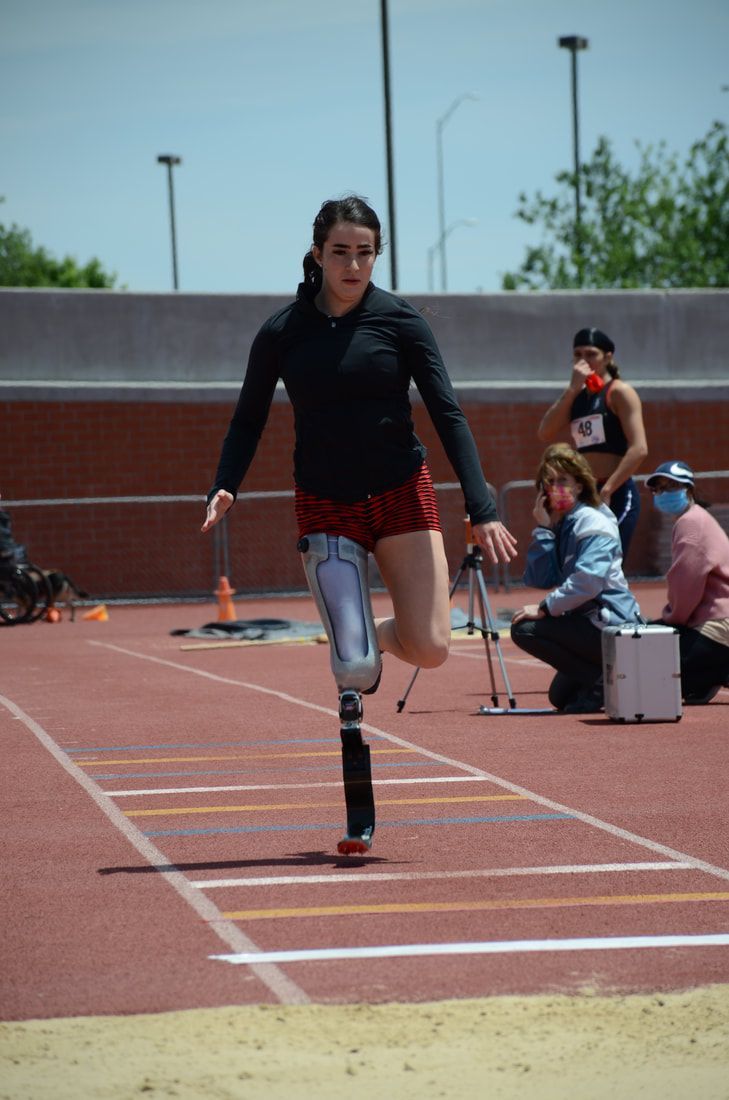 Athlete with a prosthetic leg sprints down the long jump runway