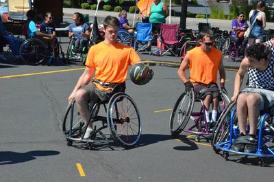 Young player in orange dribbles past a player in a checkered jersey