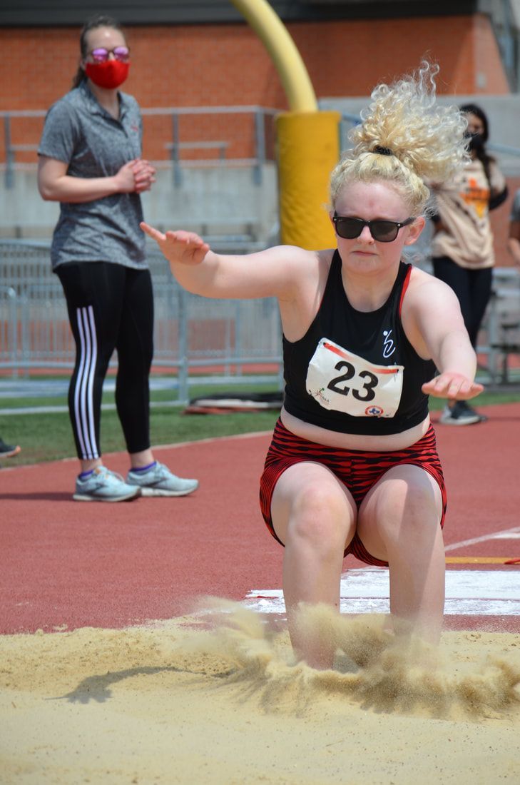 Long jumper wearing bib 23 lands in the sand pit at the Texas Regional Games