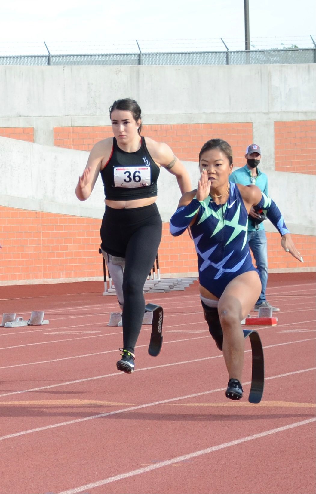 Two sprinters on running blades race side by side down the track