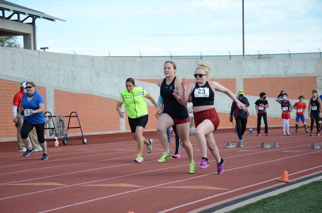 Group of runners leaves the start line, led by an athlete in bib 23