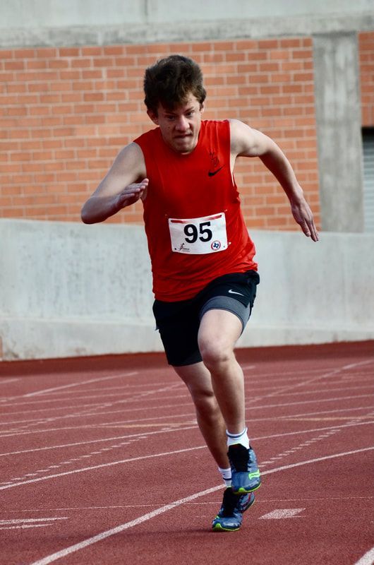 Sprinter in a red top, bib 95, drives hard out of the start