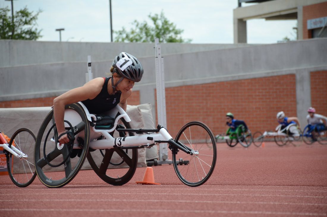 Wheelchair racer in a white racing chair, number 13, waits as others warm up