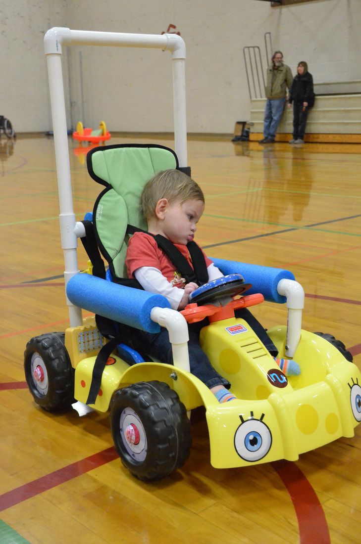 Toddler in a yellow SpongeBob ride-on car fitted with a PVC frame