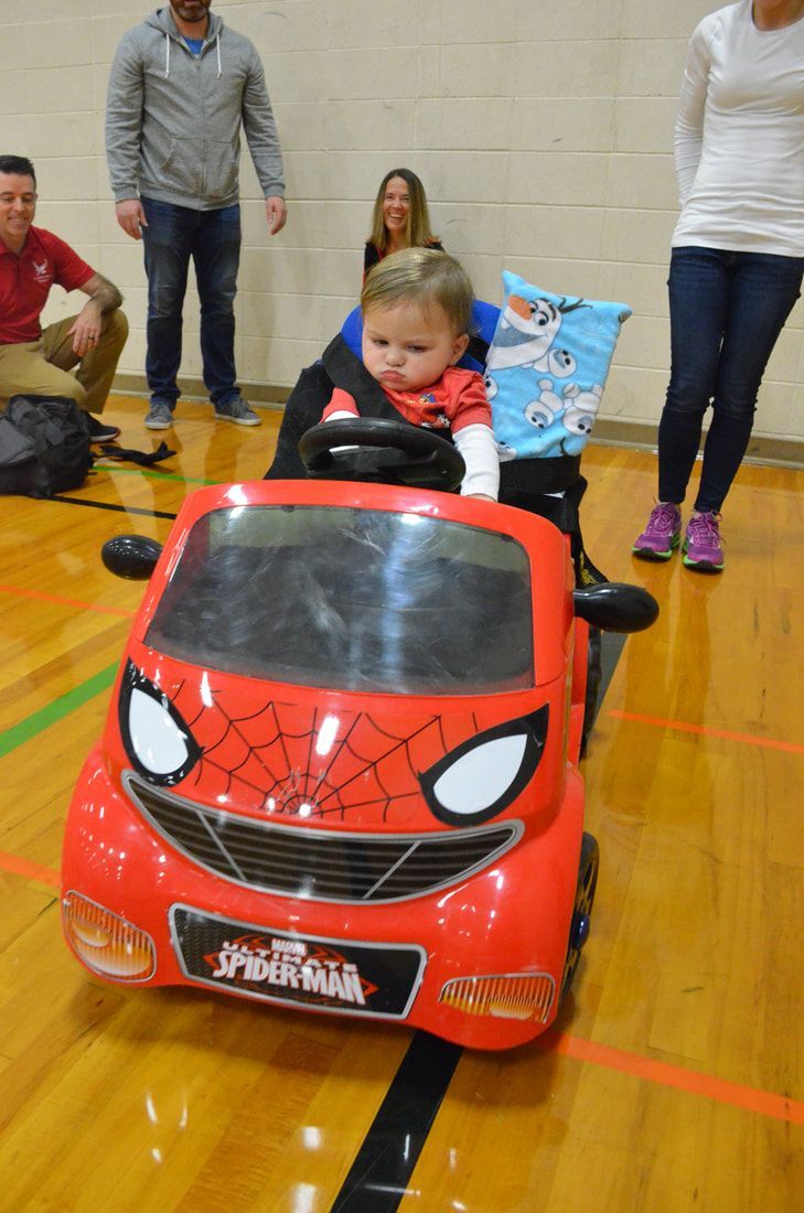 Toddler drives a red Spider-Man ride-on car toward the camera