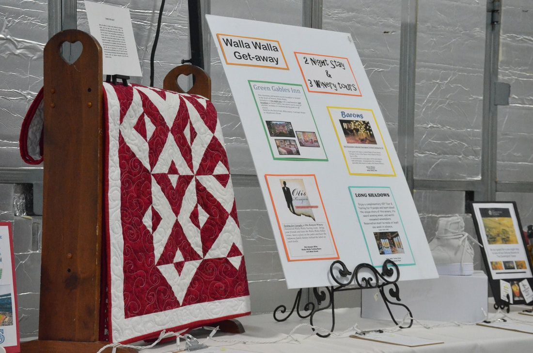 Red and white quilt beside a Walla Walla Get-away auction package