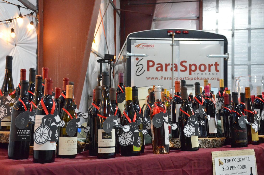Cork pull wine bottles at $20 per cork in front of the ParaSport trailer