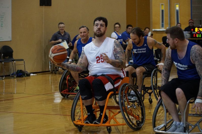 Player #25 in white dribbles past defenders in blue BC jerseys