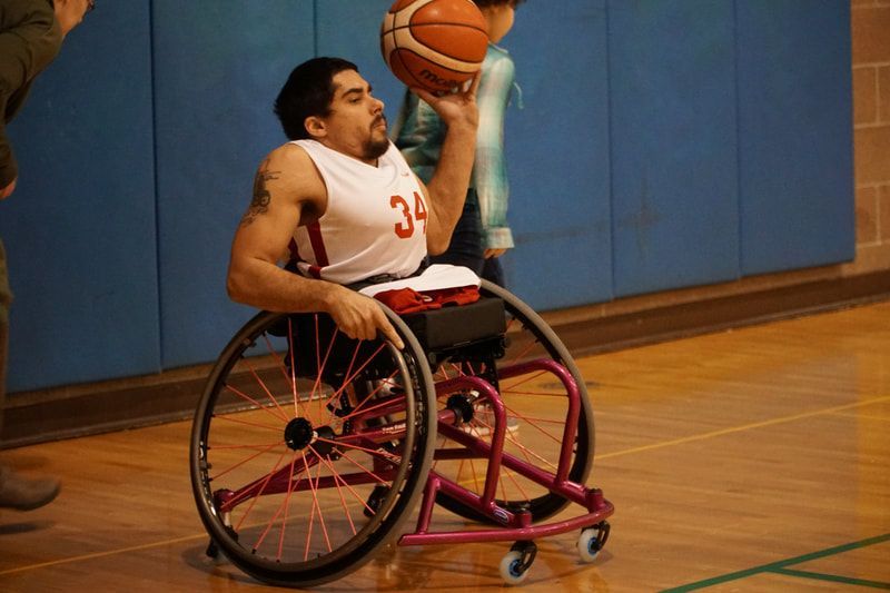 Player #34 in white holds the ball overhead to make a pass