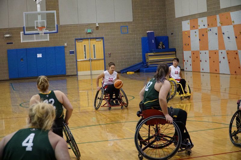 Player #32 in white dribbles toward defenders in green jerseys
