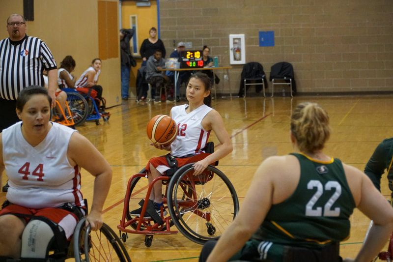 Player #12 in white holds the ball as #22 in green defends