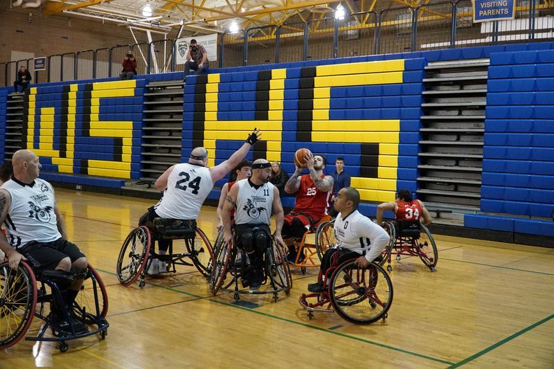Player #24 in white raises a hand to defend near the WSHS bleachers