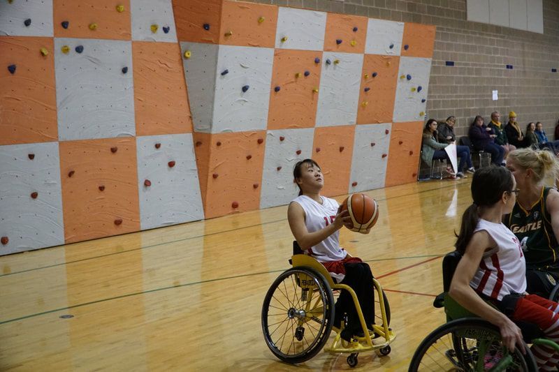 Player in white prepares to pass beside an orange and gray climbing wall