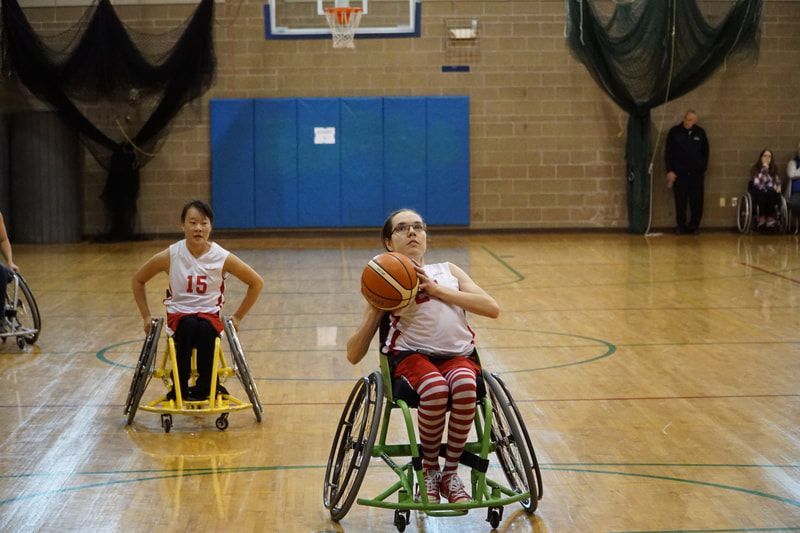 Player in white with striped socks lines up a shot as #15 looks on