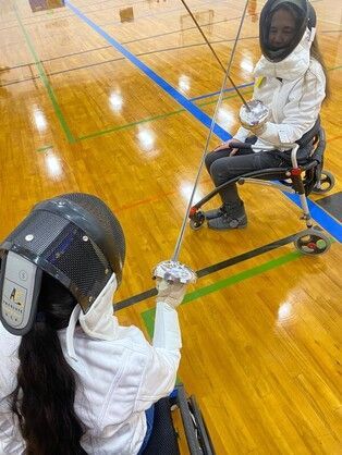 Parafencer's view across crossed blades toward a seated opponent