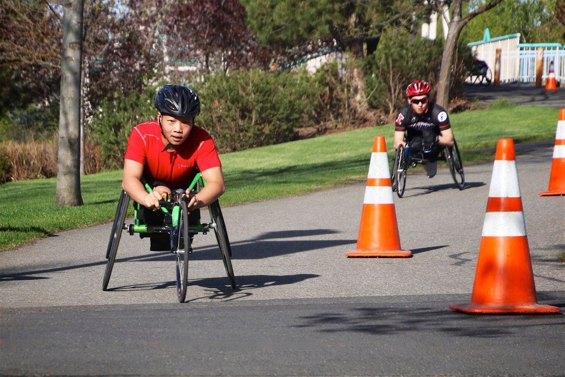 Racer in a red shirt leads a racer in a red helmet through a coned turn