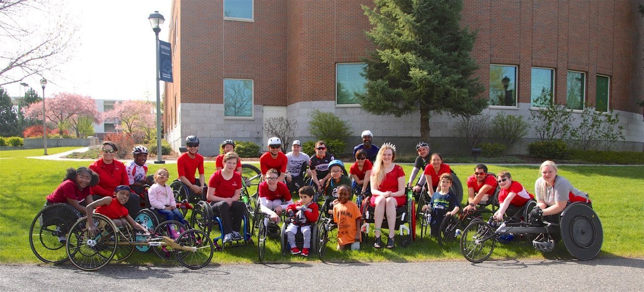 ParaSport Spokane athletes and families pose with racing chairs at Bloomsday