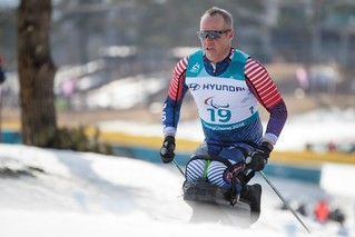 Paralympian Sean Halsted races a sit-ski in a Team USA suit