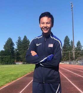 Young athlete in a Team USA jacket stands on a track with arms crossed