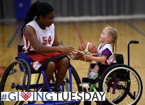 Player in jersey 54 hands a basketball to a young child, #GivingTuesday