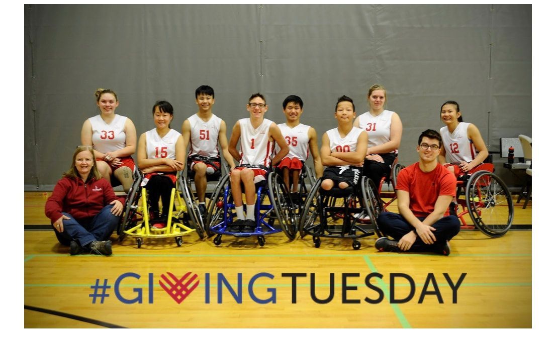 Wheelchair basketball team poses in white jerseys above a #GivingTuesday banner