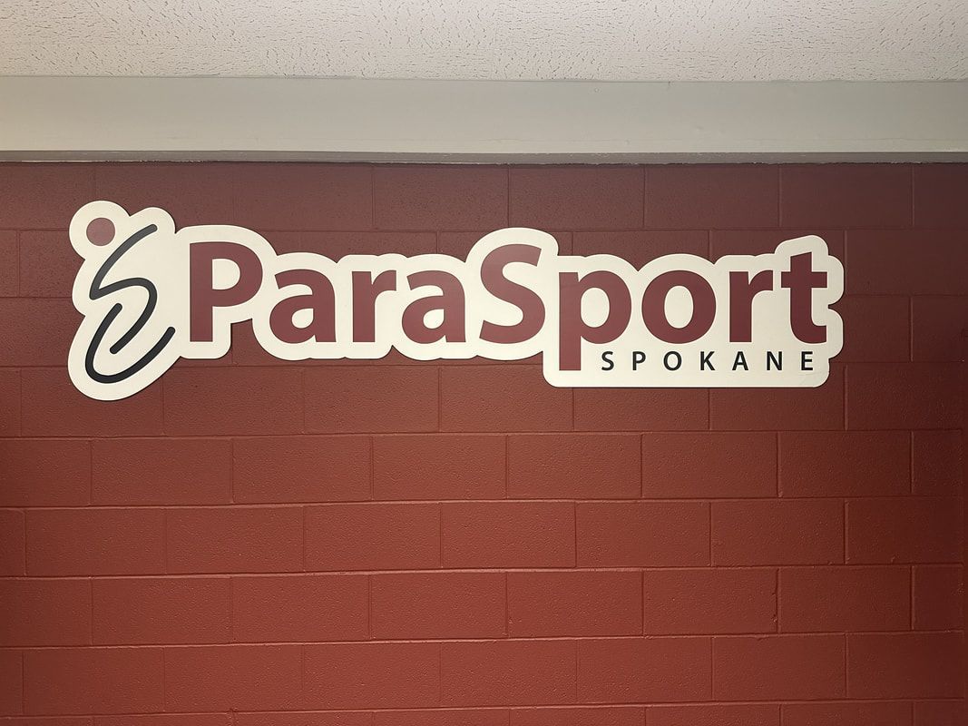 ParaSport Spokane logo sign on a red brick wall