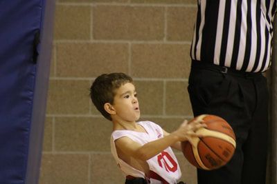 Young player in jersey 0 passes the ball next to a referee