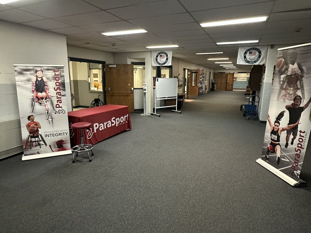 Hallway at ParaSport HQ with ParaSport banners and a red draped welcome table
