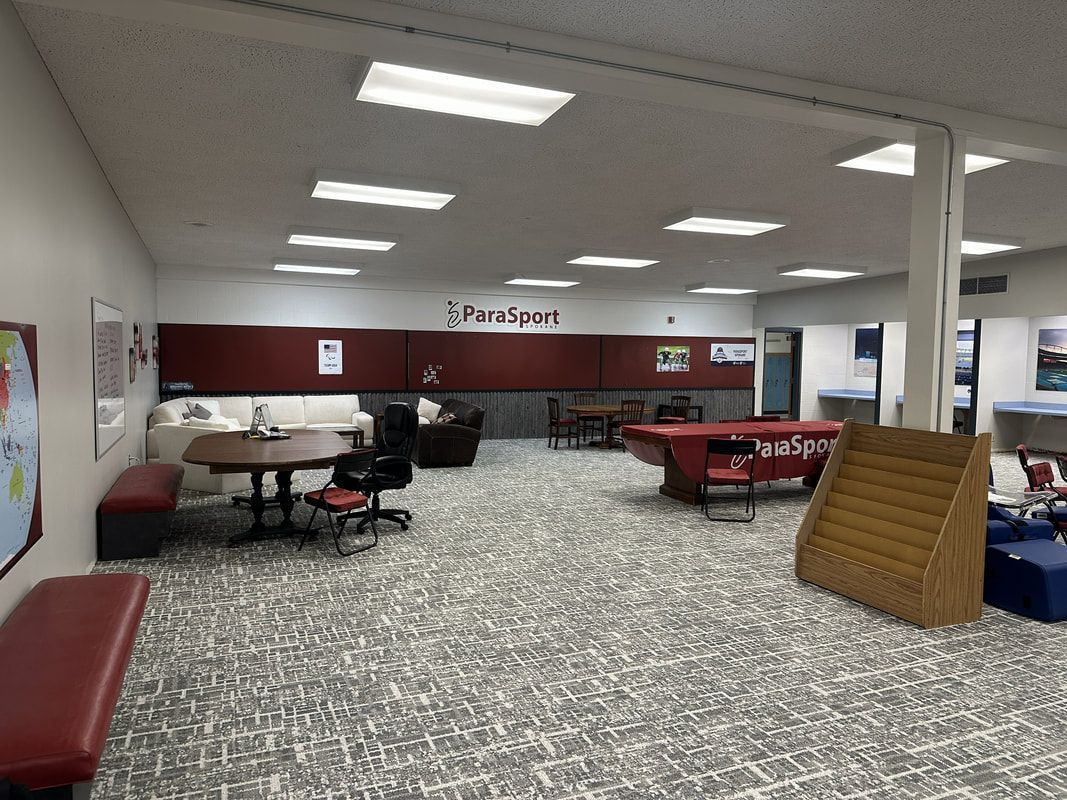 Lounge at ParaSport HQ with couches, tables and a ParaSport sign on the wall