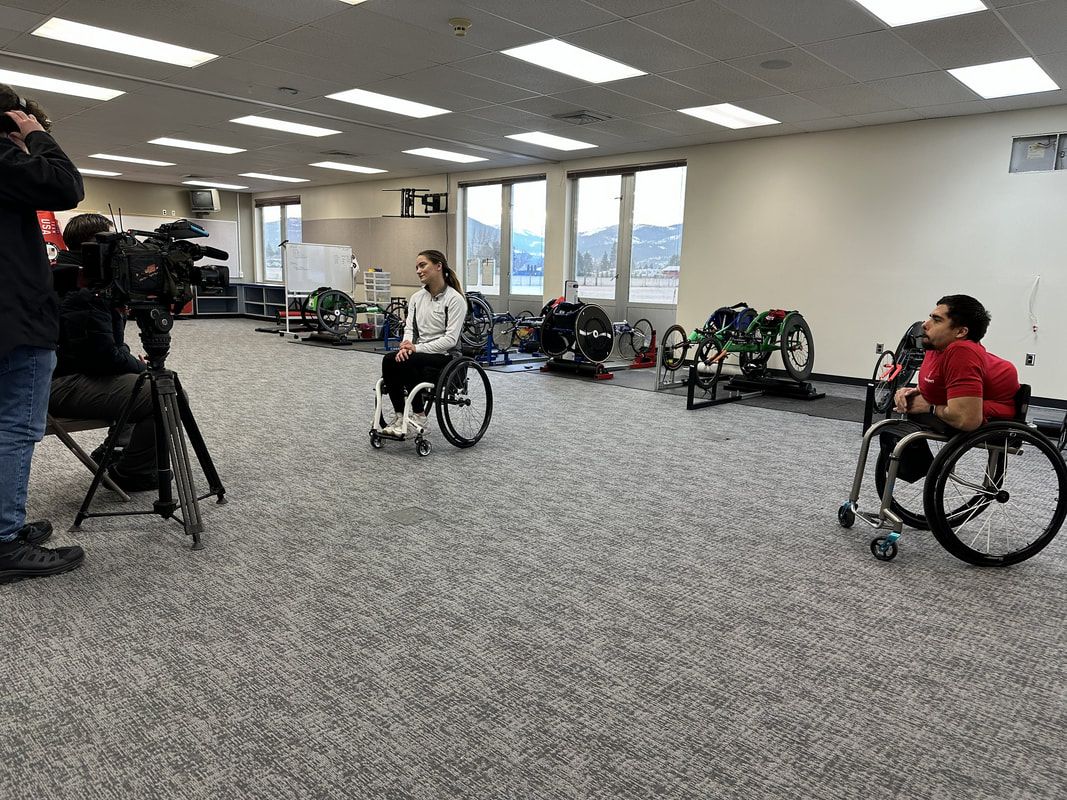 Video camera records two athletes in wheelchairs in the training room