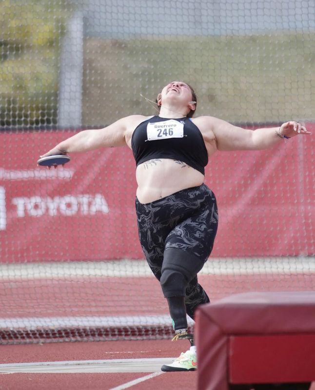 Discus thrower with a prosthetic leg winds up inside the throwing cage