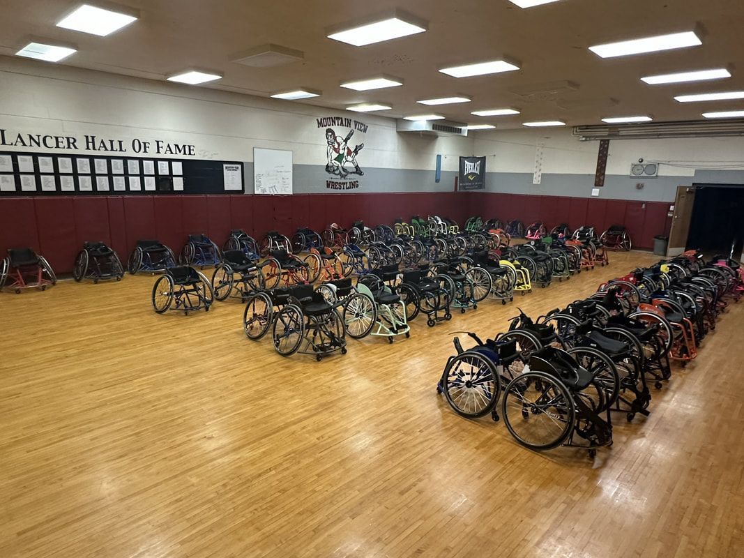 Rows of sport wheelchairs in front of the Lancer Hall of Fame wall