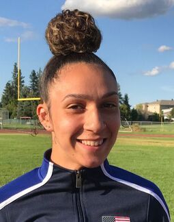 Jaleen Roberts, hair in a bun, smiles in a Team USA jacket outdoors