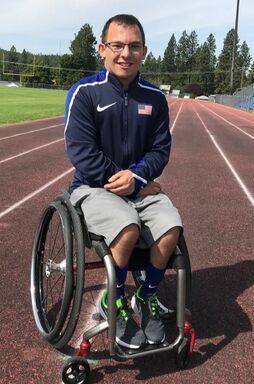 Isaiah Rigo in a Team USA jacket and shorts sits in his wheelchair